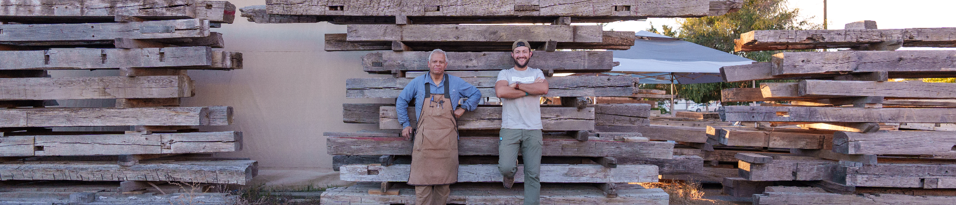 The QuarterSawn team in front of stacked reclaimed timbers